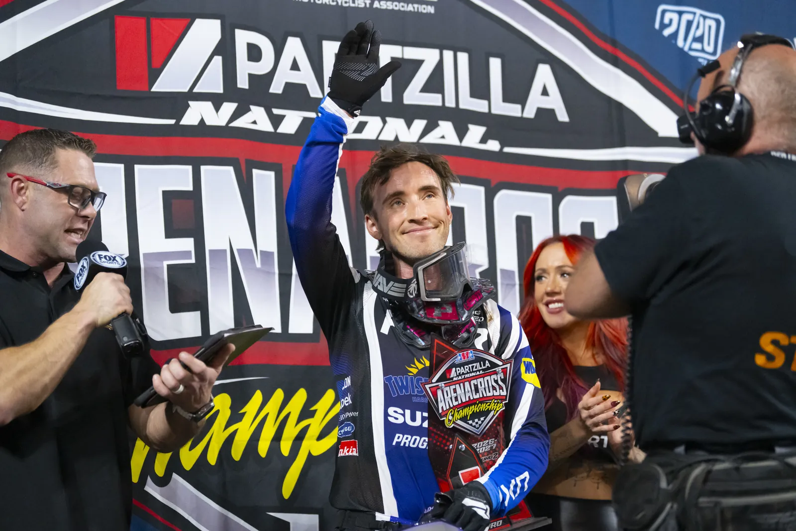 Kyle Peters waving to the crowd on the podium
